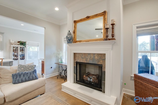 sitting room featuring a tile fireplace, recessed lighting, wood finished floors, baseboards, and crown molding