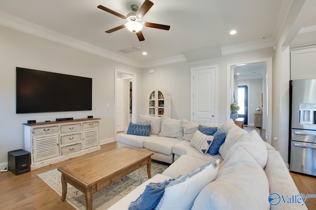 living room with ornamental molding and light wood-style flooring