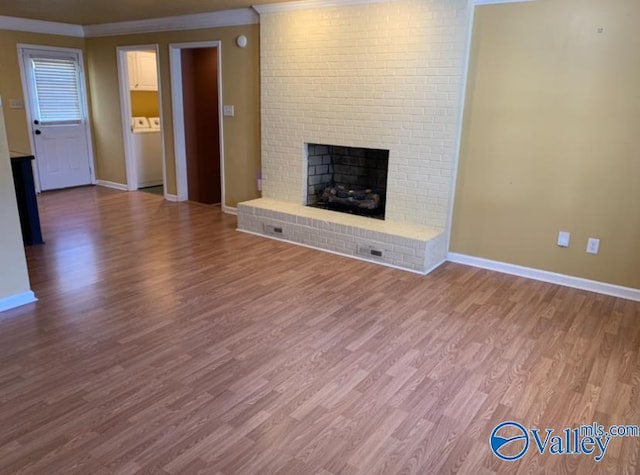 unfurnished living room featuring ornamental molding, a fireplace, wood finished floors, and baseboards