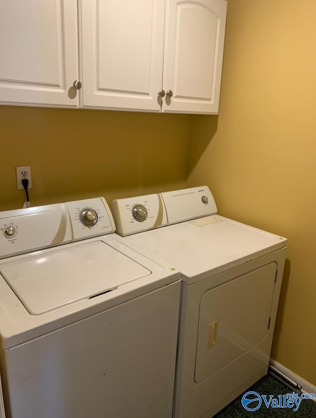 laundry room with cabinet space, independent washer and dryer, and baseboards