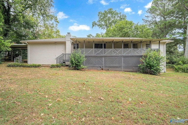 rear view of property with a yard and a carport