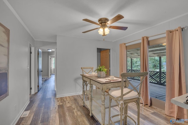 dining space with hardwood / wood-style floors, crown molding, and ceiling fan