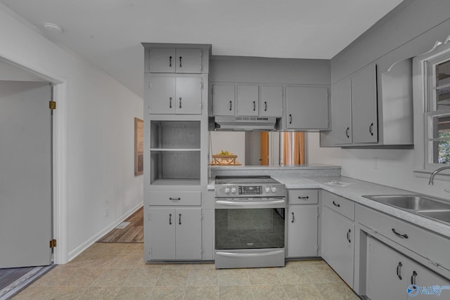 kitchen featuring stainless steel electric stove, gray cabinets, and sink