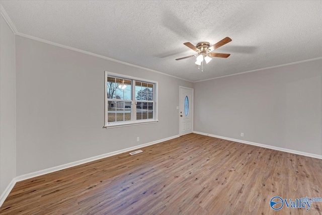 unfurnished room featuring ceiling fan, a textured ceiling, crown molding, and light wood-type flooring