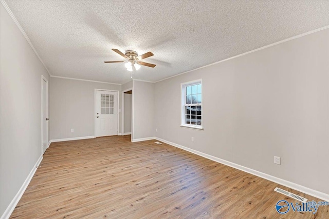 empty room with light hardwood / wood-style floors, a textured ceiling, ornamental molding, and ceiling fan