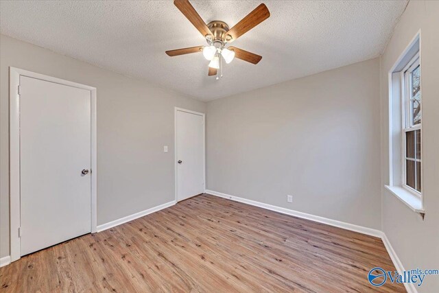 empty room featuring ceiling fan, a textured ceiling, and light hardwood / wood-style floors