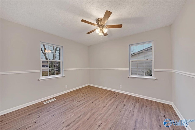 spare room with ceiling fan, a textured ceiling, and light hardwood / wood-style flooring