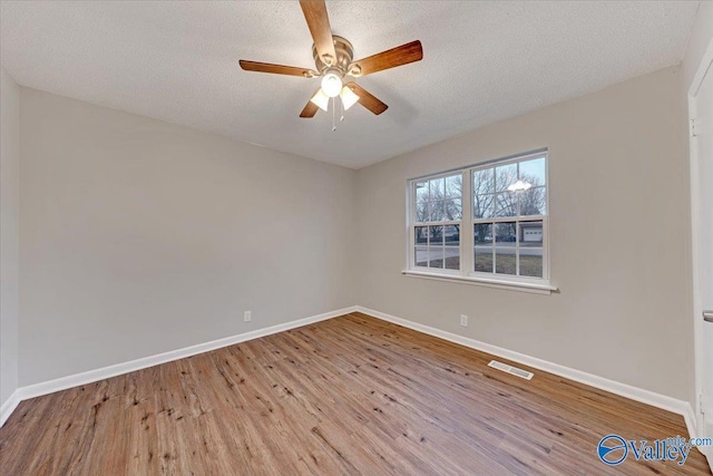 empty room featuring a textured ceiling, ceiling fan, and light hardwood / wood-style floors