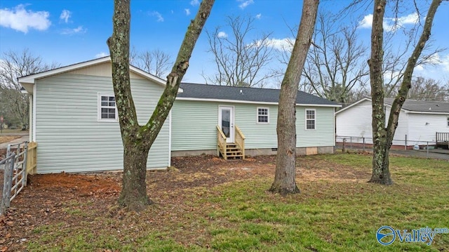 rear view of house featuring a yard