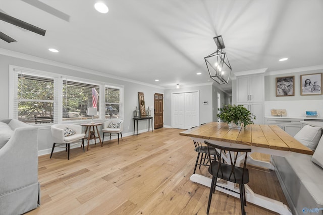 dining room featuring crown molding, light hardwood / wood-style flooring, and a notable chandelier