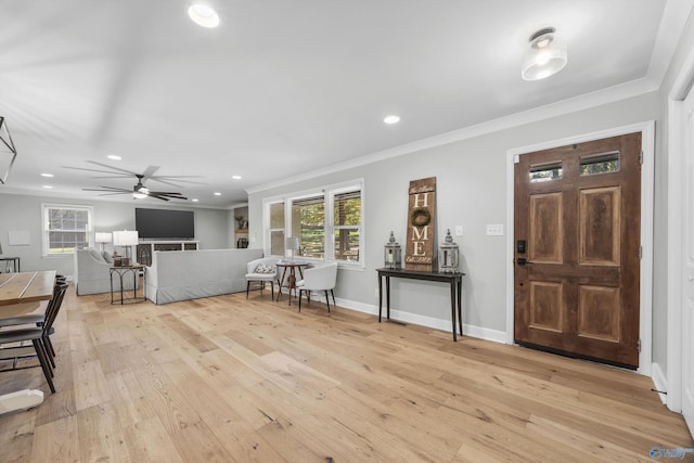 foyer entrance featuring crown molding, light wood-type flooring, and ceiling fan