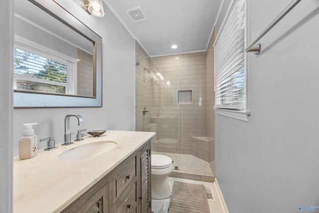 bathroom with tiled shower, toilet, tile patterned flooring, ornamental molding, and vanity