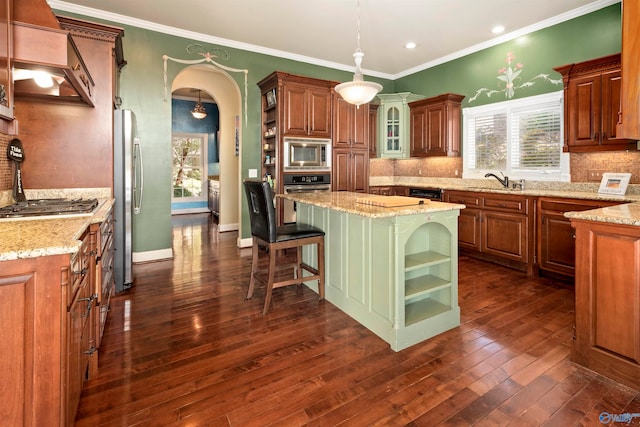 kitchen with tasteful backsplash, stainless steel appliances, hanging light fixtures, a center island, and dark hardwood / wood-style floors