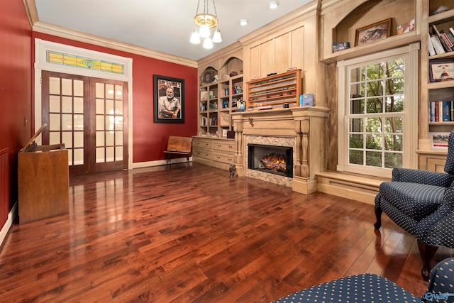 interior space with built in features, a premium fireplace, french doors, crown molding, and dark hardwood / wood-style flooring