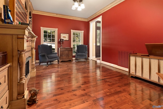 living area featuring hardwood / wood-style flooring and ornamental molding