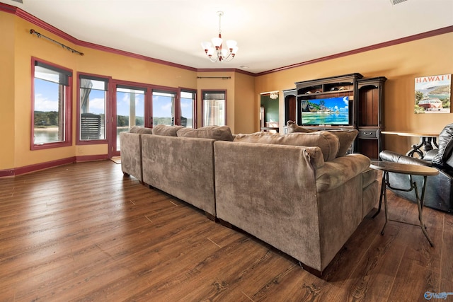 living room featuring dark hardwood / wood-style flooring, ornamental molding, and an inviting chandelier