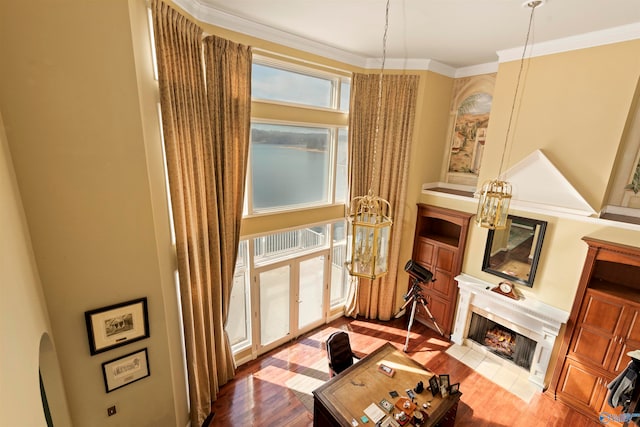 living room with hardwood / wood-style flooring, crown molding, and a fireplace