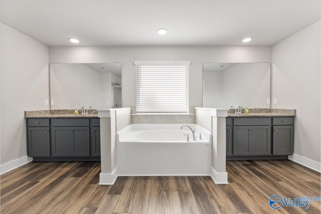 246 Tybee Dr, Madison, AL 35756 - full bathroom featuring two vanities, wood finished floors, a bath, and recessed lighting