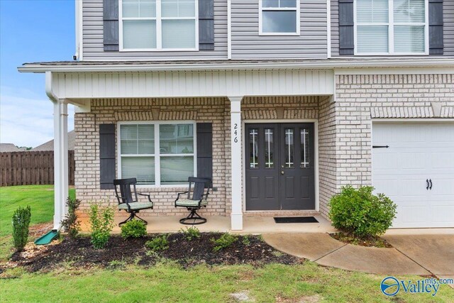 246 Tybee Dr, Madison, AL 35756 - view of exterior entry with brick siding, covered porch, and a garage