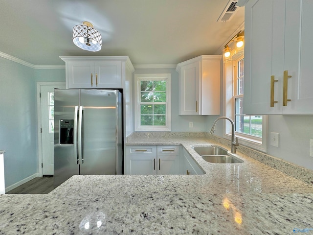 kitchen with stainless steel fridge, sink, and white cabinets