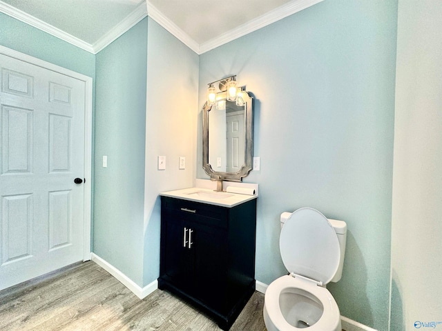 bathroom featuring crown molding, hardwood / wood-style floors, vanity, and toilet