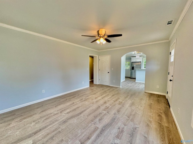 unfurnished room featuring ornamental molding, light wood-type flooring, and ceiling fan