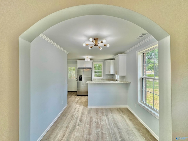 kitchen with a healthy amount of sunlight, light wood-type flooring, stainless steel fridge with ice dispenser, and white cabinetry