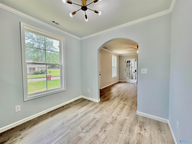 spare room with light hardwood / wood-style flooring, ceiling fan with notable chandelier, plenty of natural light, and ornamental molding