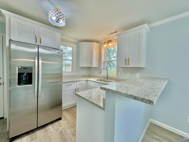 kitchen featuring a wealth of natural light, white cabinetry, stainless steel fridge with ice dispenser, and sink