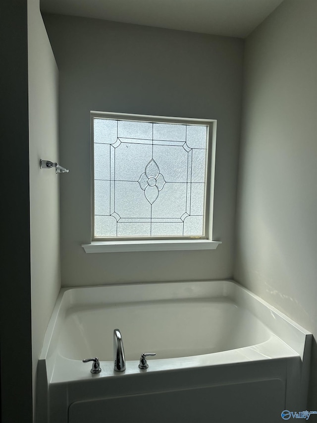 bathroom with a wealth of natural light and a bath