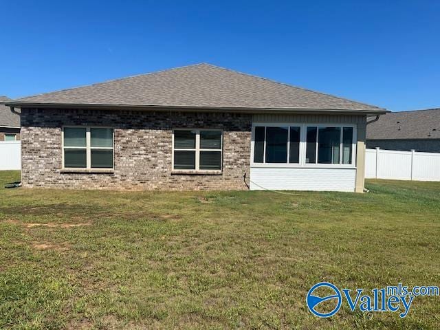 rear view of property with a lawn