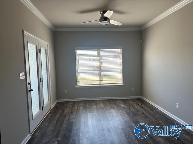 unfurnished room with ceiling fan, ornamental molding, dark wood-style flooring, and baseboards