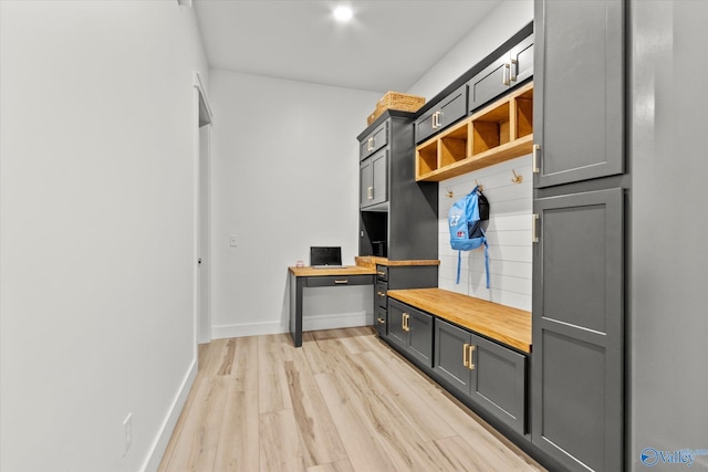 mudroom featuring built in desk and light hardwood / wood-style flooring