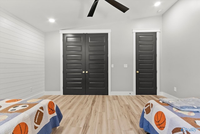 foyer entrance with ceiling fan, wood-type flooring, and vaulted ceiling