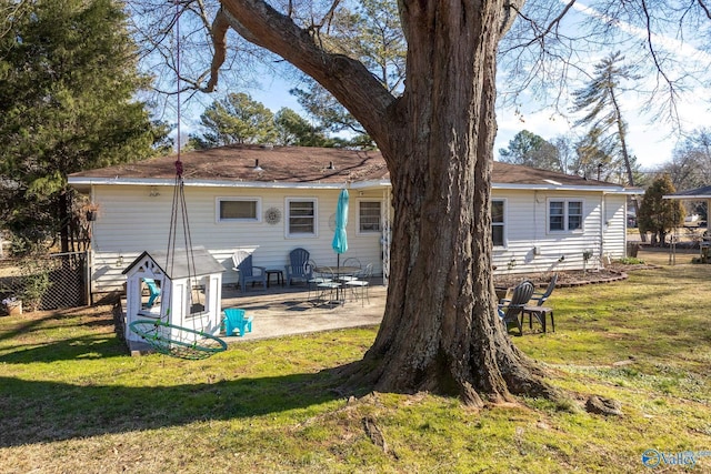 rear view of property featuring a patio area, fence, and a lawn