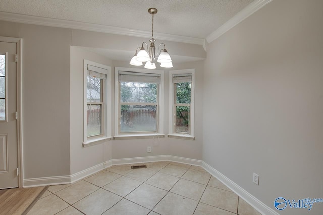 unfurnished dining area featuring crown molding, an inviting chandelier, a textured ceiling, and light tile patterned floors