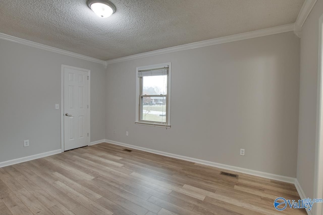 empty room with ornamental molding, light hardwood / wood-style flooring, and a textured ceiling