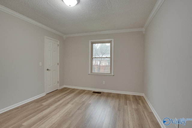 spare room featuring ornamental molding, a textured ceiling, and light hardwood / wood-style floors