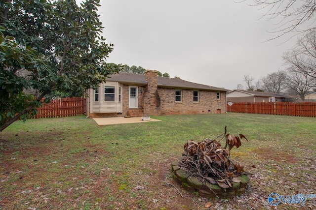 back of house with a yard and a patio