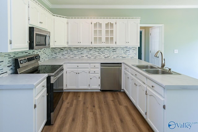 kitchen featuring crown molding, appliances with stainless steel finishes, white cabinets, and decorative backsplash