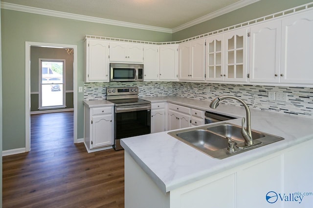 kitchen featuring dark wood-type flooring, sink, white cabinetry, appliances with stainless steel finishes, and kitchen peninsula