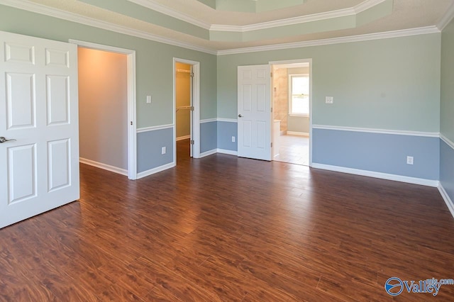 empty room featuring crown molding, dark hardwood / wood-style flooring, and a tray ceiling