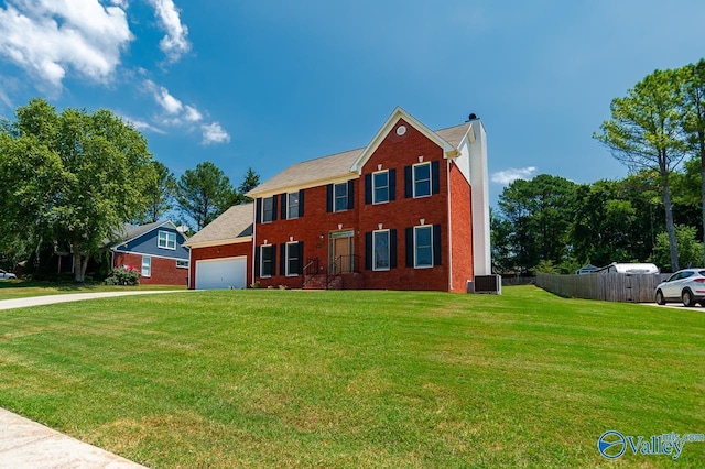 view of front of house with cooling unit, a garage, and a front yard