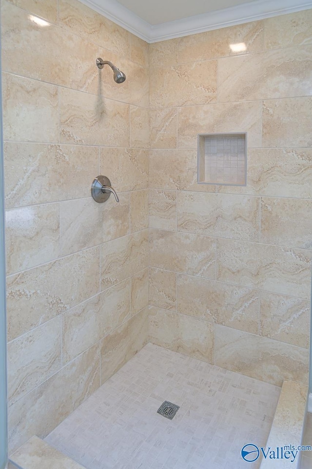 bathroom with crown molding and tiled shower