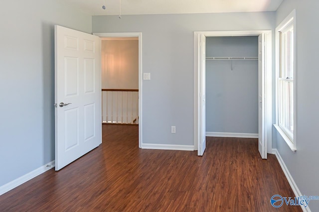 unfurnished bedroom featuring dark hardwood / wood-style flooring and a closet