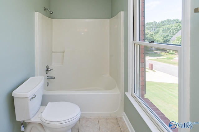 bathroom with tile patterned flooring, bathtub / shower combination, and toilet