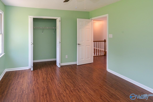 unfurnished bedroom featuring dark hardwood / wood-style floors, ceiling fan, and a closet