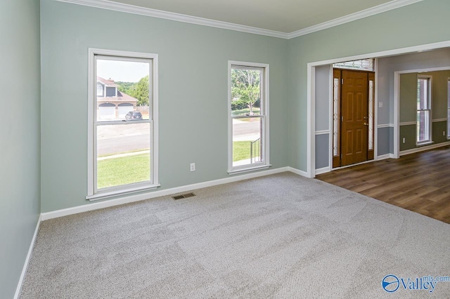 unfurnished room featuring crown molding and dark carpet