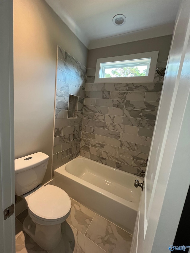 bathroom featuring tiled shower / bath and toilet