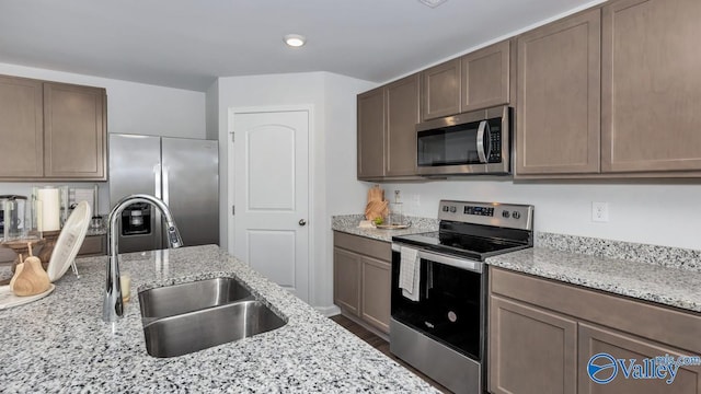 18882 Wicklow Cir, Athens, AL 35613 - kitchen featuring appliances with stainless steel finishes, a sink, light stone counters, and recessed lighting